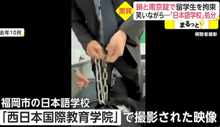 Image of a teacher at the school padlocking a student to himself.